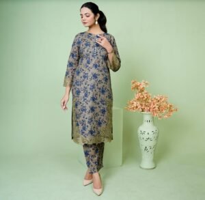 Stylish woman in an embroidered Eastern dress posing in a studio setting.