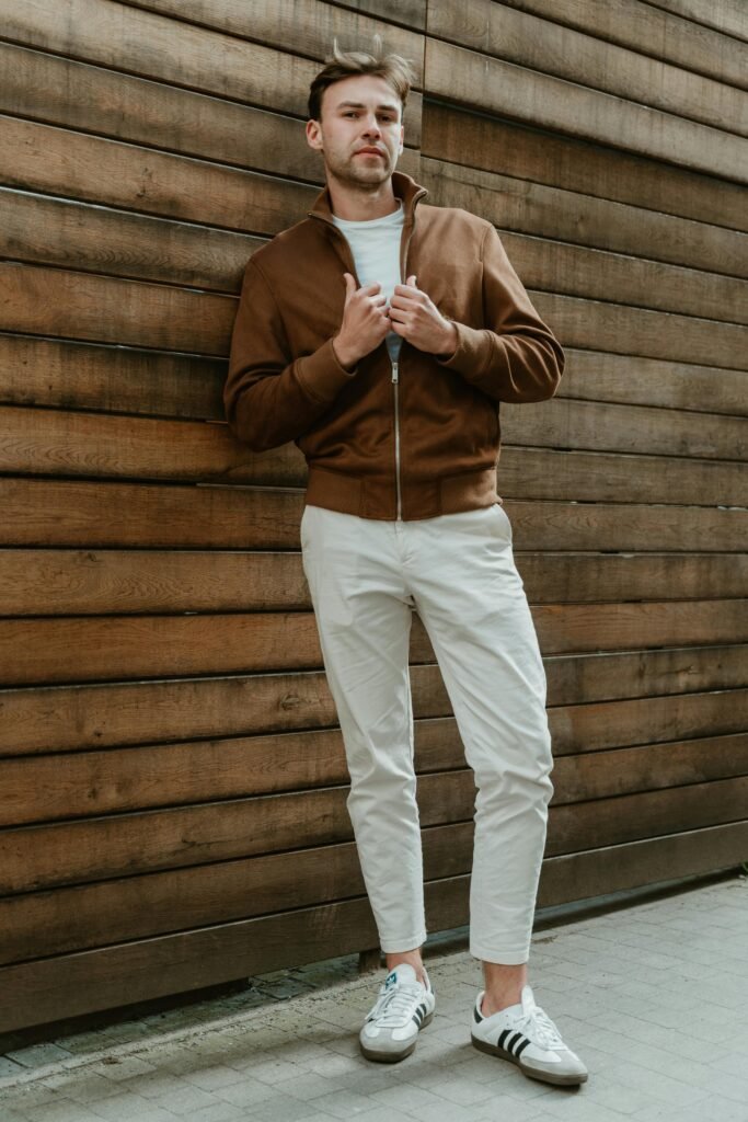 Stylish man posing against wooden wall, showcasing casual urban fashion in Berlin.