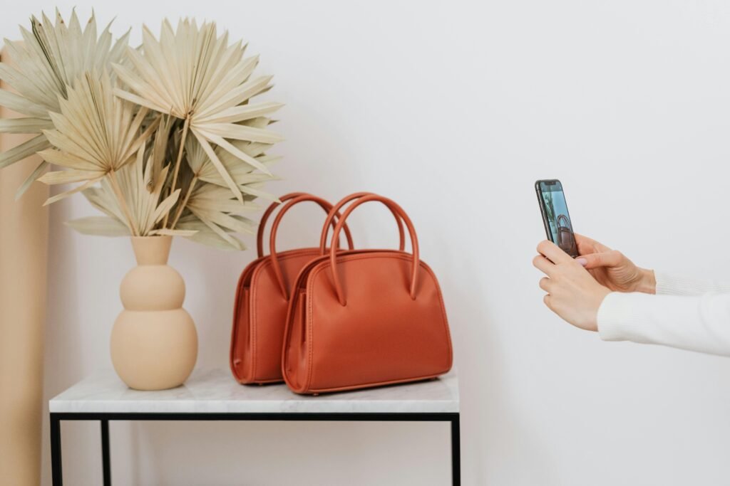 Two elegant leather bags next to a decorative vase, photographed.